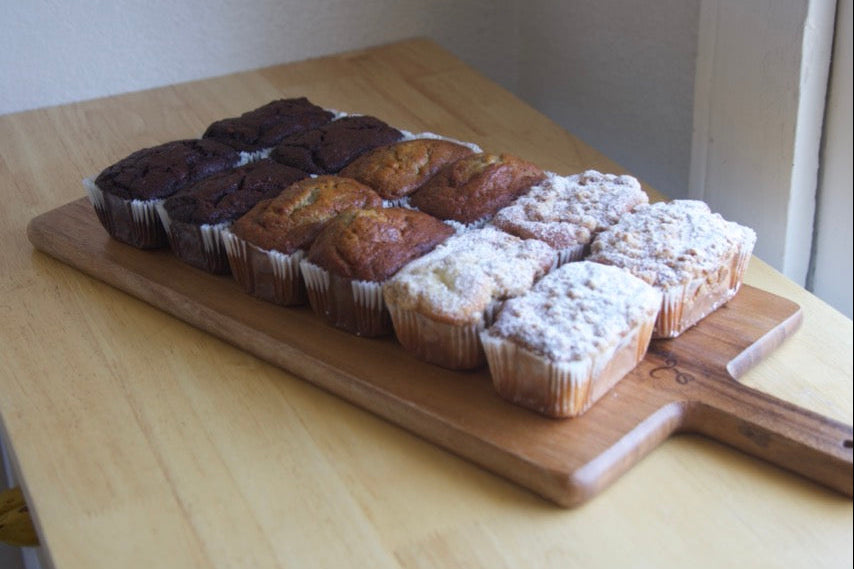 sourdough banana bread, coffee cake, and quick breads on a wooden cutting board